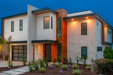 Modelo de fachada de casa beige minimalista grande de dos plantas con revestimiento de estuco y tejado plano