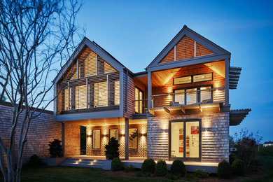 Inspiration for a large modern beige two-story wood exterior home remodel in New York with a shingle roof