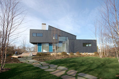 Mid-sized trendy gray two-story wood house exterior photo in New York with a shed roof and a shingle roof