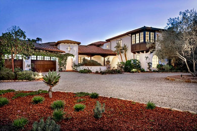 Large mediterranean white two-story adobe exterior home idea in Santa Barbara with a hip roof