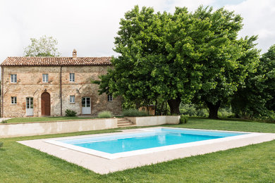 Aménagement d'une grande façade de petite villa méditerranéenne en brique à un étage avec un toit à deux pans.