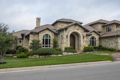 Example of a trendy one-story stone exterior home design in Austin with a tile roof