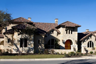 Inspiration for a large contemporary two-story house exterior remodel in Austin with a hip roof and a tile roof