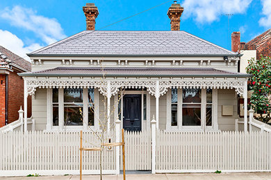 Inspiration for a medium sized and white traditional two floor house exterior in Melbourne with wood cladding and a half-hip roof.