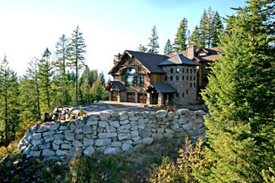 Cette photo montre une très grande façade de maison marron montagne en pierre à deux étages et plus avec un toit de Gambrel.