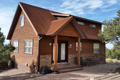 Modelo de fachada de casa marrón rural grande de tres plantas con revestimiento de madera, tejado a dos aguas y tejado de metal
