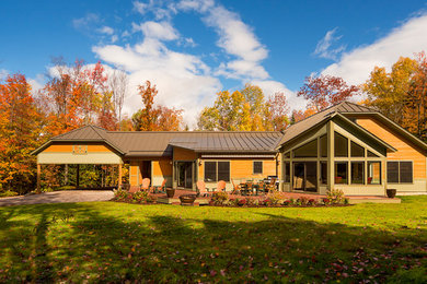 Example of a large farmhouse yellow one-story house exterior design in Burlington