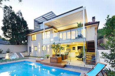 Cette photo montre une grande façade de maison beige tendance en béton à deux étages et plus avec un toit plat.