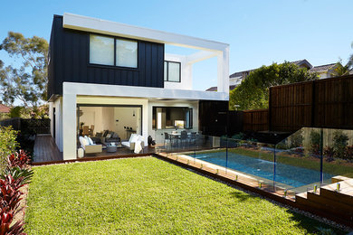 На фото: двухэтажный, белый дом среднего размера в стиле модернизм с облицовкой из металла и плоской крышей с