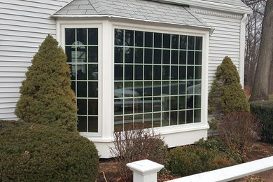 Cette photo montre une façade de maison grise chic de taille moyenne et de plain-pied avec un revêtement en vinyle.