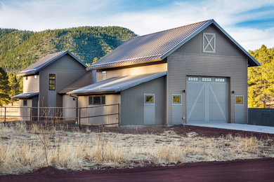 Immagine della facciata di una casa marrone country a due piani con tetto a capanna e copertura in metallo o lamiera