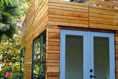 Imagen de fachada de casa minimalista de dos plantas con revestimiento de madera