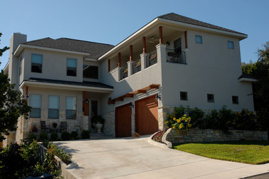 Inspiration for a mid-sized transitional beige two-story stucco exterior home remodel in Austin with a hip roof