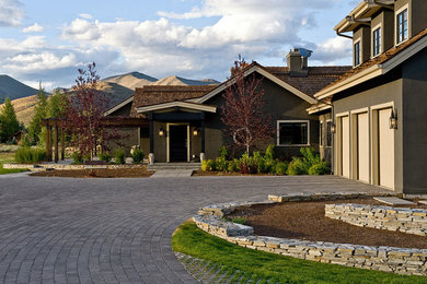 Large transitional green two-story stucco house exterior photo in Boise with a clipped gable roof and a shingle roof