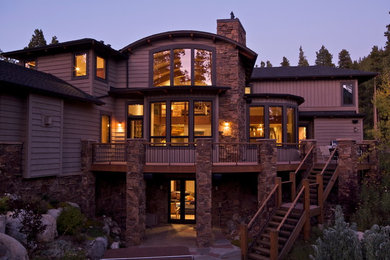 Ispirazione per la facciata di una casa beige rustica con rivestimento in pietra, tetto a padiglione e copertura a scandole
