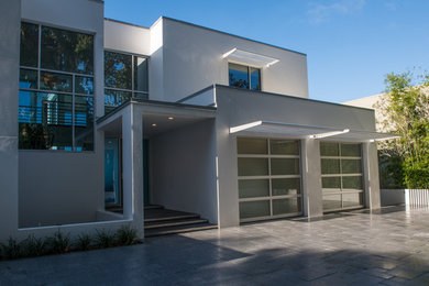 Modelo de fachada blanca moderna extra grande de tres plantas con revestimiento de estuco y tejado plano