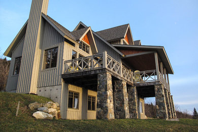 Modelo de fachada de casa beige rústica de tamaño medio de tres plantas con revestimiento de madera, tejado a dos aguas y tejado de teja de madera