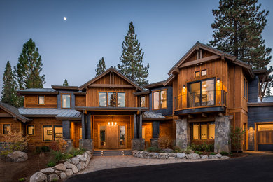 Inspiration pour une grande façade de maison marron chalet en bois à un étage avec un toit à deux pans et un toit mixte.