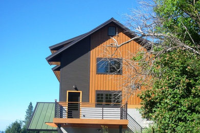 Diseño de fachada de casa beige clásica de tamaño medio de dos plantas con revestimiento de madera, tejado de un solo tendido y tejado de metal