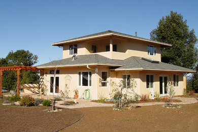 Foto de fachada de casa beige tradicional de tamaño medio de dos plantas con revestimiento de estuco, tejado a la holandesa y tejado de teja de madera