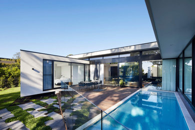 Modelo de fachada de casa gris minimalista de tamaño medio de una planta con revestimiento de hormigón, tejado plano y techo verde