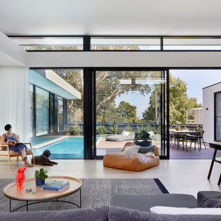 Imagen de fachada de casa gris, minimalista, grande, de una planta, con revestimiento de hormigón, tejado plano y techo verde