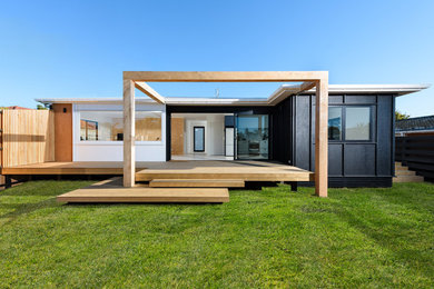 Diseño de fachada de casa negra costera pequeña de una planta con revestimiento de madera