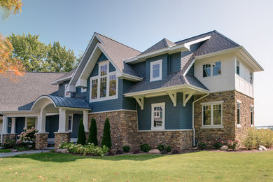 Example of a large arts and crafts blue two-story mixed siding house exterior design in Other with a shingle roof