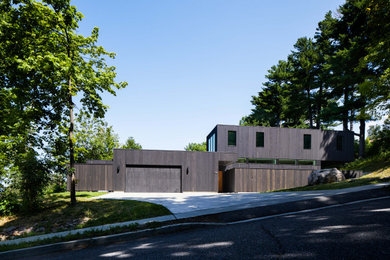 Mittelgroßes, Zweistöckiges Modernes Haus mit schwarzer Fassadenfarbe und Flachdach in Burlington