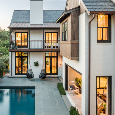 Inspiration for a transitional white two-story brick gable roof remodel in Houston