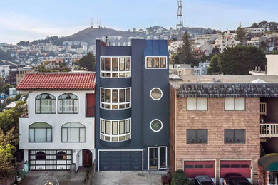 Inspiration for a large transitional blue three-story stucco exterior home remodel in San Francisco with a metal roof