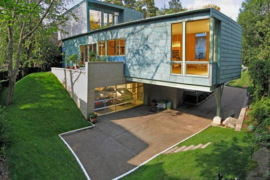Diseño de fachada verde contemporánea de tamaño medio de tres plantas con revestimiento de metal y tejado plano
