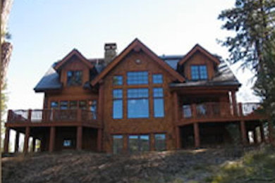 Foto de fachada marrón de tres plantas con revestimiento de madera