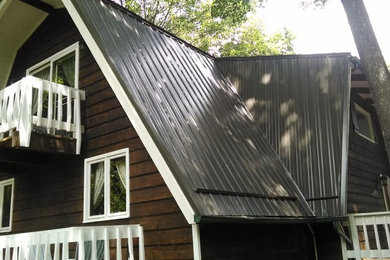 Example of a large cottage three-story mixed siding house exterior design in Charlotte with a gambrel roof and a metal roof