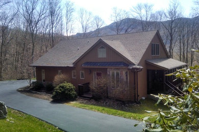 Example of a mid-sized mountain style brown one-story wood exterior home design in Charlotte with a shingle roof