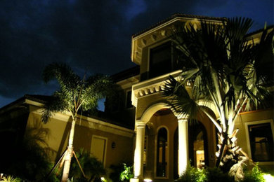 Inspiration for a large tropical beige two-story stucco house exterior remodel in Other with a hip roof and a shingle roof