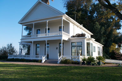 Aménagement d'une façade de maison blanche classique de taille moyenne et à un étage avec un revêtement en vinyle.