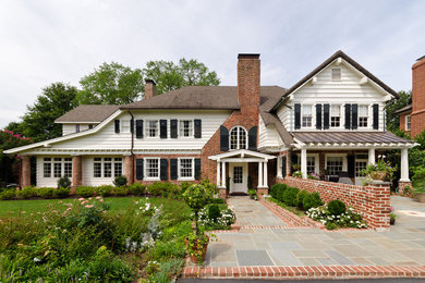 Diseño de fachada de casa blanca clásica grande de dos plantas con revestimientos combinados, tejado a cuatro aguas y tejado de teja de madera