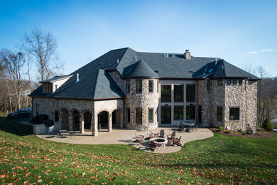 Foto de fachada de casa gris clásica grande de dos plantas con revestimiento de piedra, tejado a cuatro aguas y tejado de teja de madera