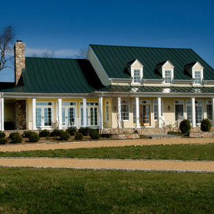 Example of a huge cottage yellow two-story stucco exterior home design in DC Metro