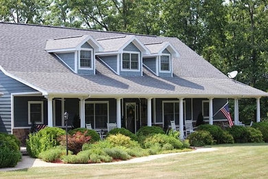 Diseño de fachada de casa azul clásica de tamaño medio de dos plantas con revestimientos combinados y tejado de teja de madera