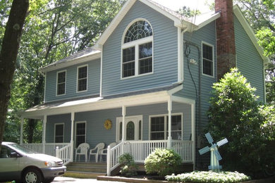 Imagen de fachada de casa azul tradicional grande de dos plantas con revestimiento de madera, tejado a dos aguas y tejado de teja de madera
