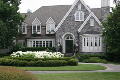 Inspiration for a large timeless gray two-story stone exterior home remodel in Nashville