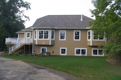 Exempel på ett stort brunt hus, med två våningar och vinylfasad