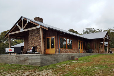 Imagen de fachada de estilo de casa de campo de una planta con revestimiento de madera