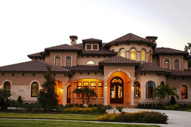 Photo of a large and beige mediterranean two floor render house exterior in Tampa with a hip roof.