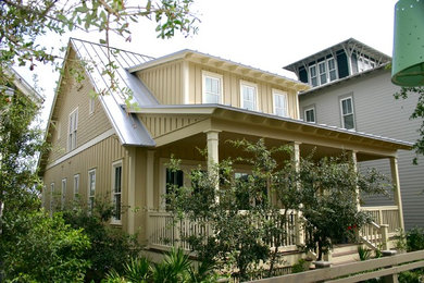 Diseño de fachada de casa beige tradicional de tamaño medio de dos plantas con revestimiento de aglomerado de cemento, tejado a dos aguas y tejado de metal