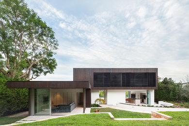 Aménagement d'une façade de maison marron moderne à un étage avec un revêtement mixte et un toit plat.