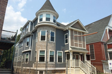Example of a three-story vinyl apartment exterior design in Boston with a shingle roof