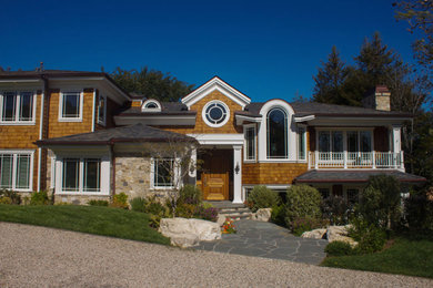 Example of a large beach style brown two-story wood house exterior design in Orange County with a hip roof and a shingle roof